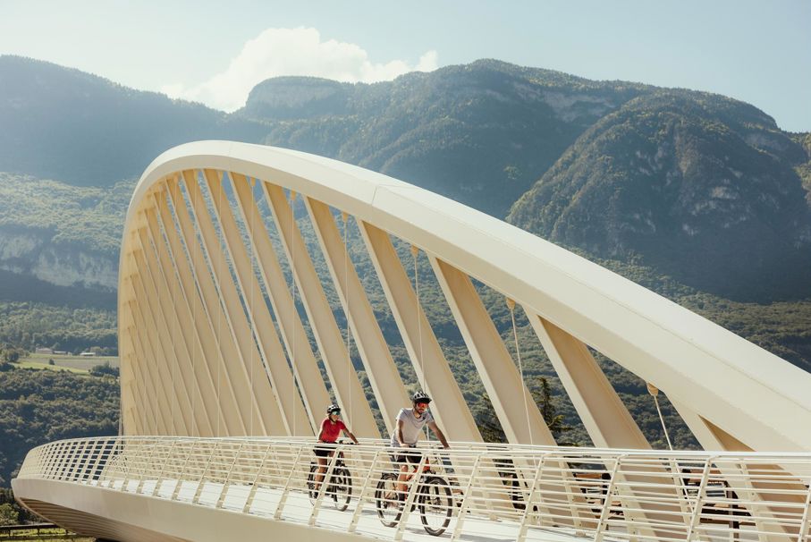 Zwei Menschen radeln über eine Brücke